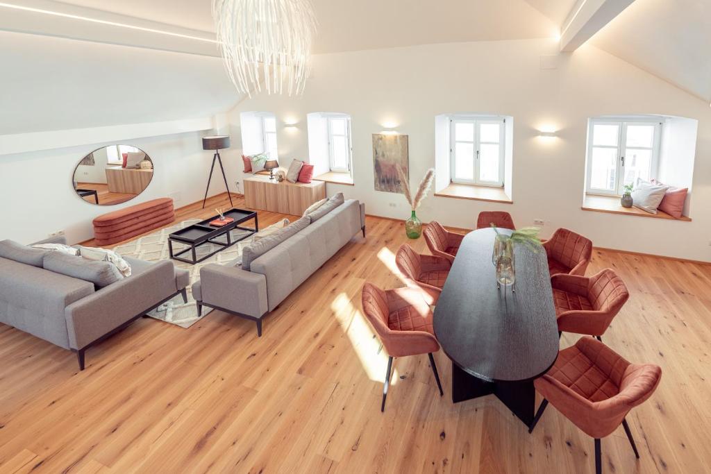 een woonkamer met een bank en een tafel en stoelen bij Penthouse MaxFux direkt in der Fußgängerzone 130m2 in Krems an der Donau