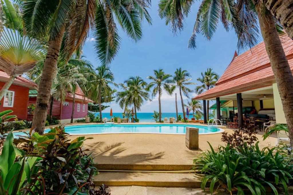 un complejo con piscina con palmeras y el océano en Chaweng Bliss Bungalow en Chaweng Beach
