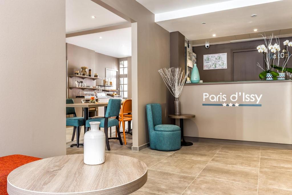 a living room with a table and blue chairs at Paris d'Issy Hôtel Porte de Versailles in Issy-les-Moulineaux