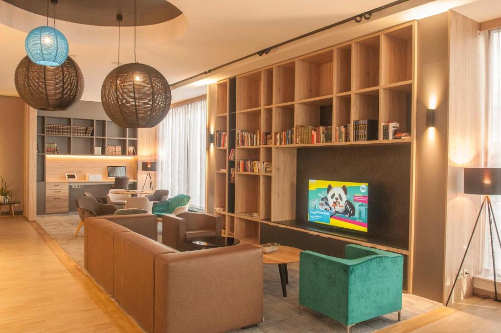- un salon avec un canapé et une télévision dans l'établissement Ostend Hotel, à Ostende