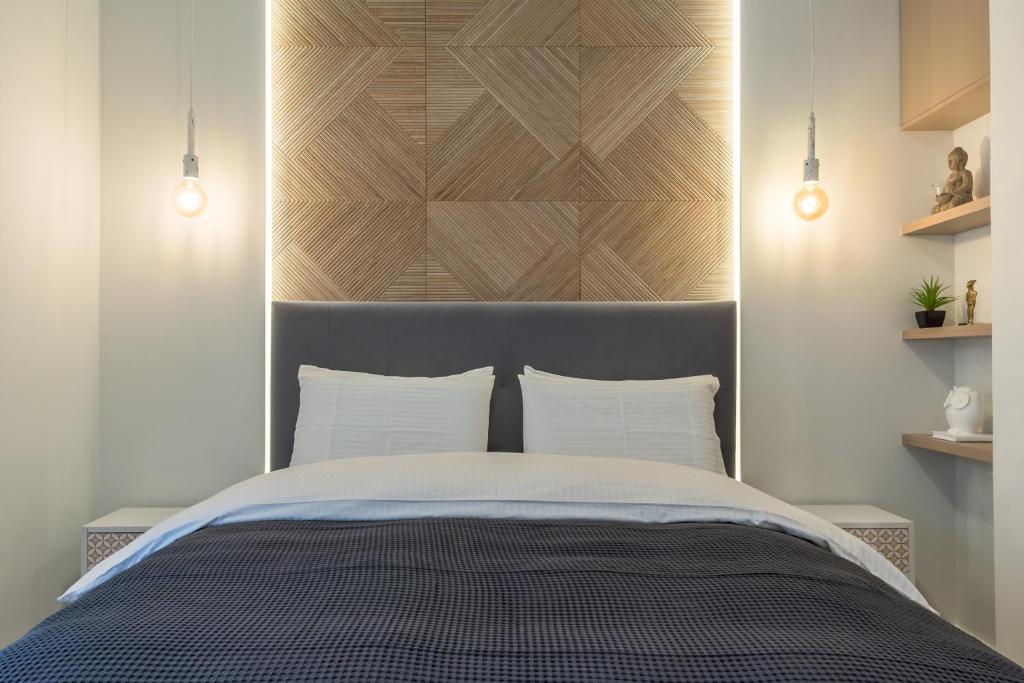 a bedroom with a bed with a wooden headboard at The Averof (Kalimarmaro) City Center Apartment in Athens