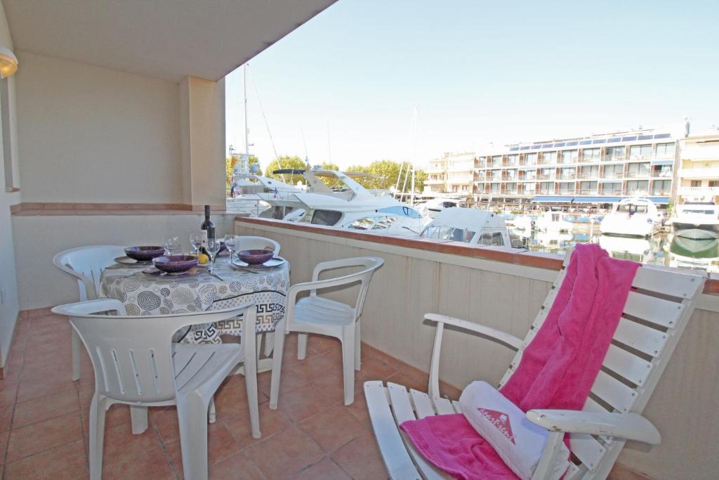 a balcony with a table and chairs and a boat at Apart-rent Apartment Port Salins 0155 in Empuriabrava