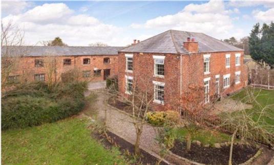 ein großes rotes Backsteingebäude mit einem Hof in der Unterkunft Hopley House in Middlewich