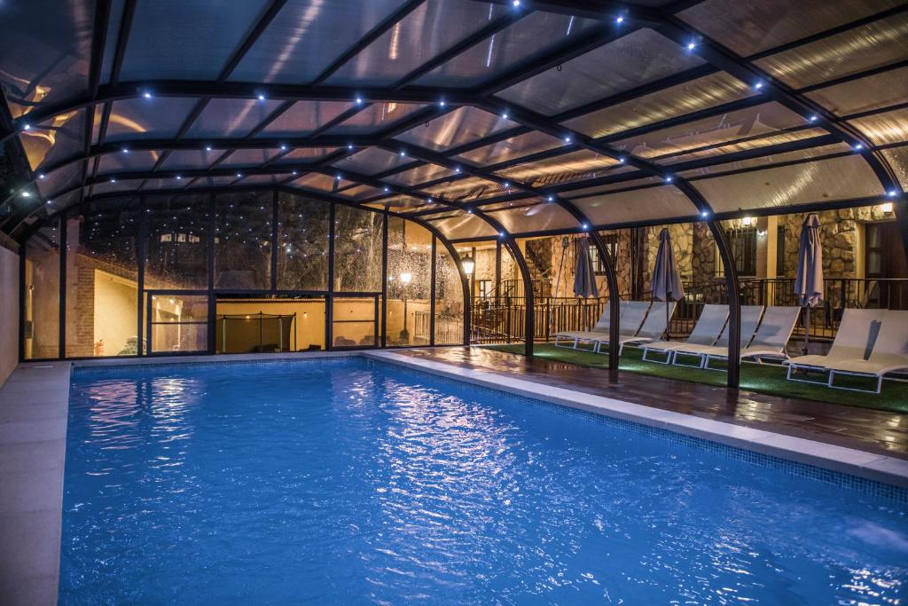 an indoor swimming pool with a pool house at EL ENCANTO DEL ALBERCHE in Villanueva de Ávila