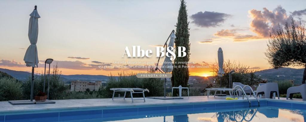 a swimming pool with a sunset in the background at Bed and Breakfast Albe in Corciano