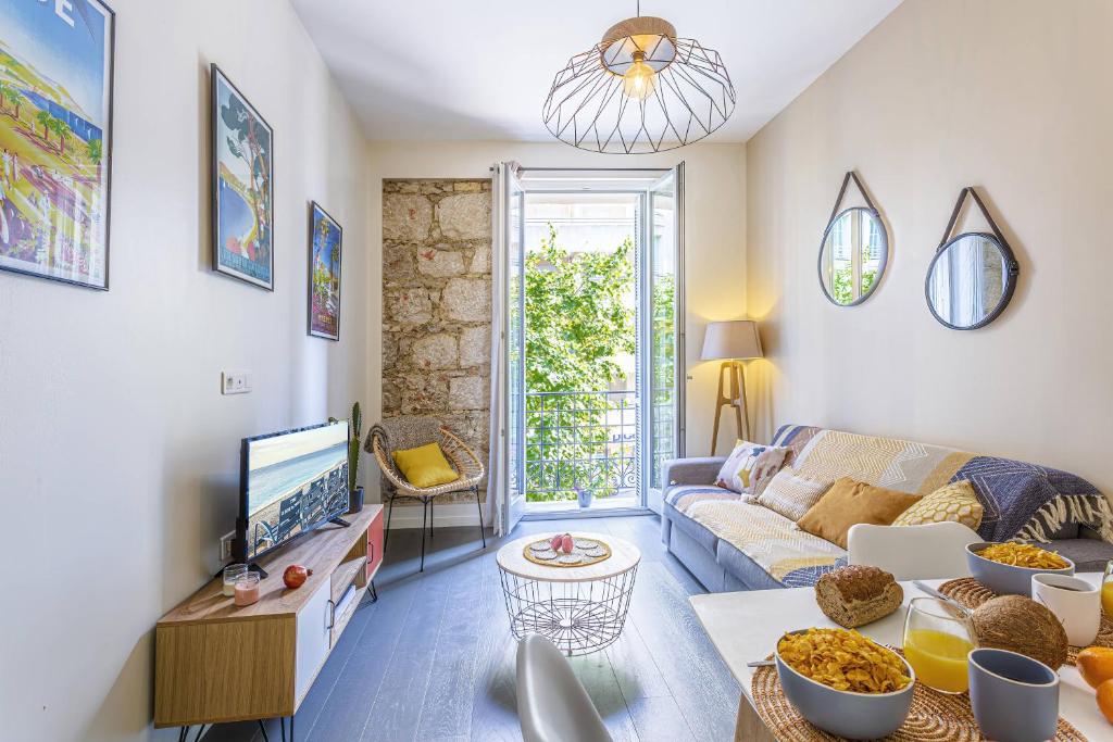 un salon avec un canapé et une télévision dans l'établissement MY CASA - GAMBETTA 33, à Nice