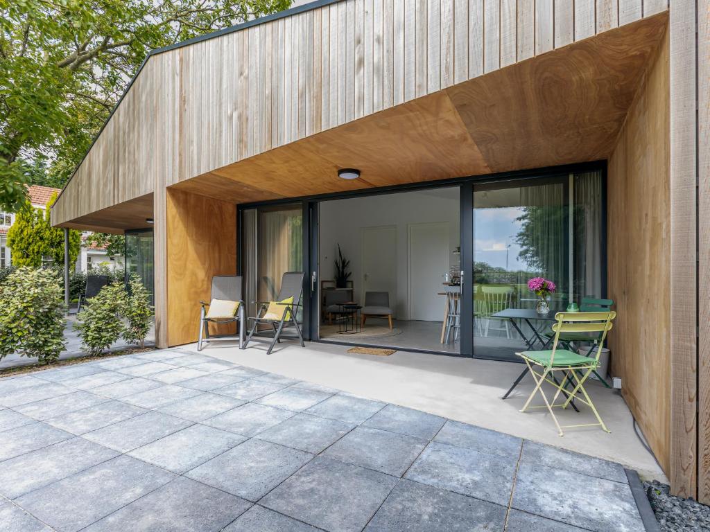 a house with glass doors and a patio at De Duinlopers- appt Zilt Zand- Strand, duinen en nabij cultuur steden in Castricum