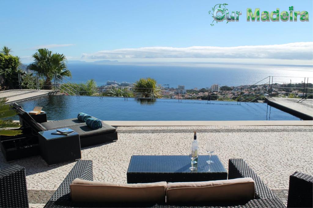 フンシャルにあるOurMadeira - Villa Luz, fabulousの水辺の景色を望むリビングルーム