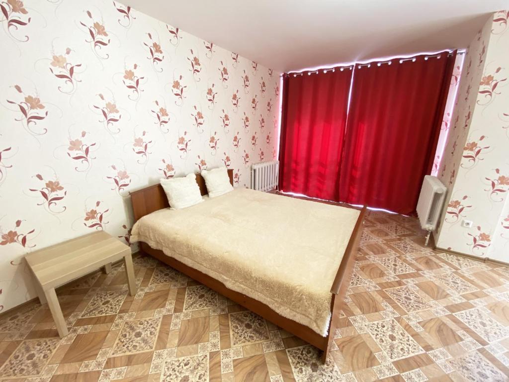 ウファにあるApartment Revolyutsionnaya 68-66のベッドルーム1室(ベッド1台、赤いカーテン付)