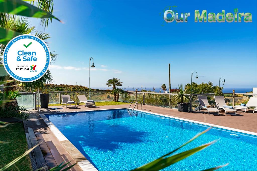 una piscina con sillas y un cartel que diga limpio y seguro en OurMadeira - Villa Sol e Mar, spacious en Caniço