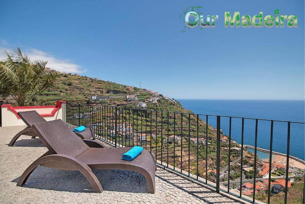 a bench sitting on top of a hill next to the ocean at OurMadeira - Casa do Júlio, Calheta beach view in Calheta