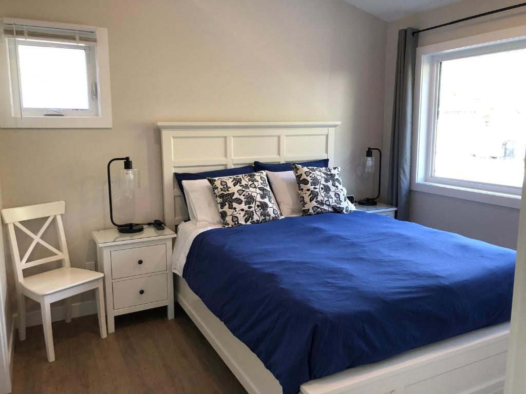 a bedroom with a bed and a chair and two windows at Mountain View Bed & Breakfast in Banff