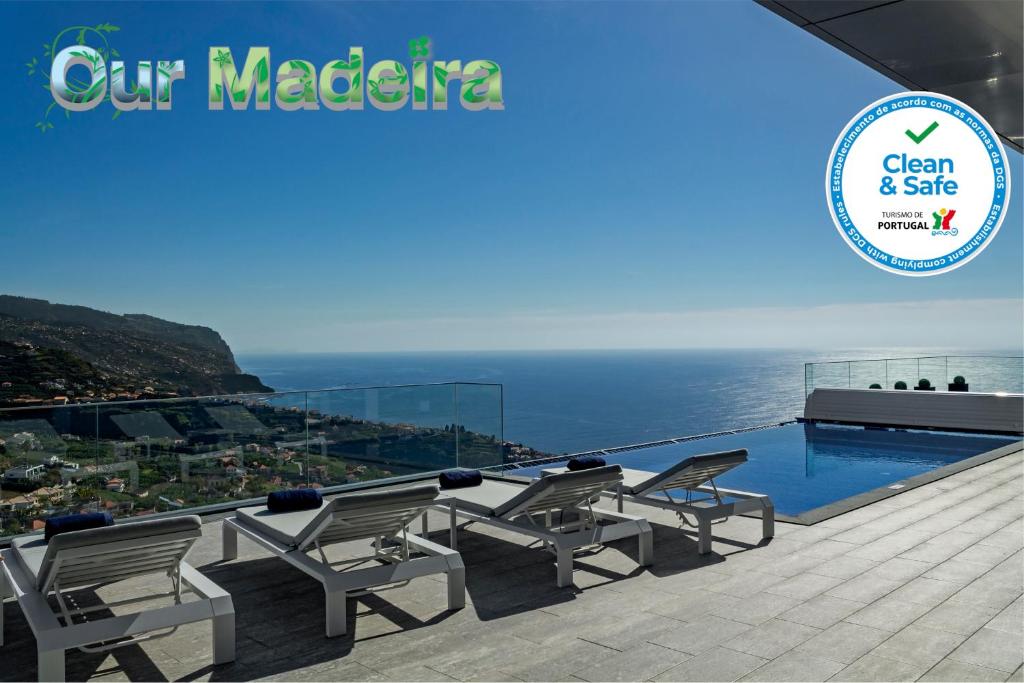 una piscina y sillas en un balcón con vistas al océano en OurMadeira - Seacrest, premium luxury, en Ponta do Sol