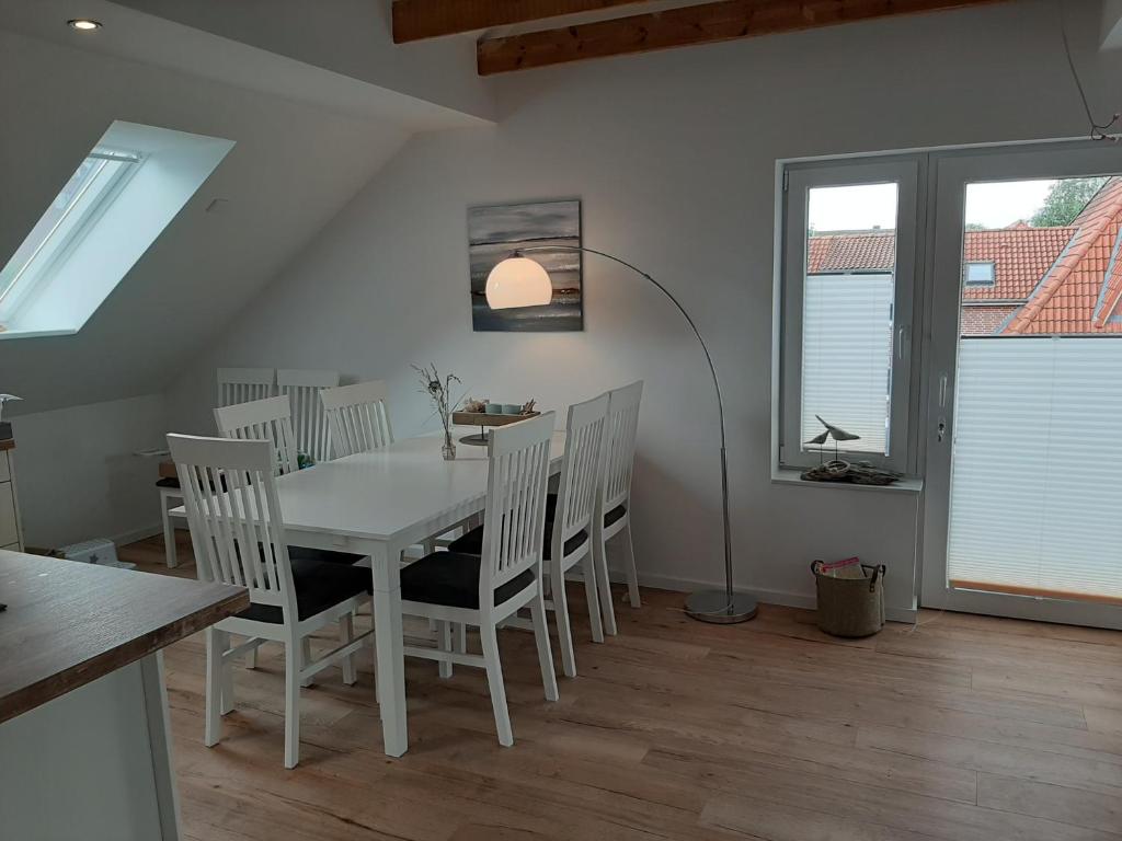 a dining room with a white table and chairs at Nordstern in Tönning