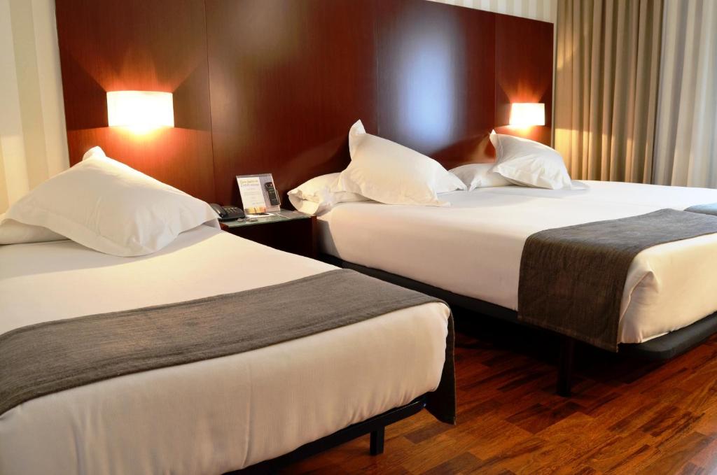 a hotel room with two beds with white pillows at Zenit Málaga in Málaga