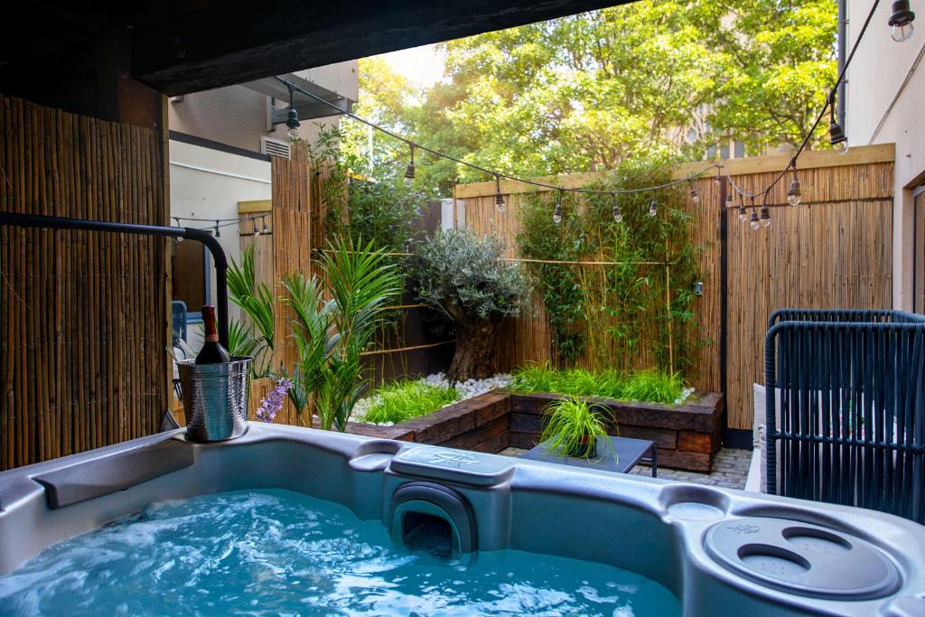 a hot tub in a backyard with a garden at The Bells - Luxury Serviced Apartments in Leeds