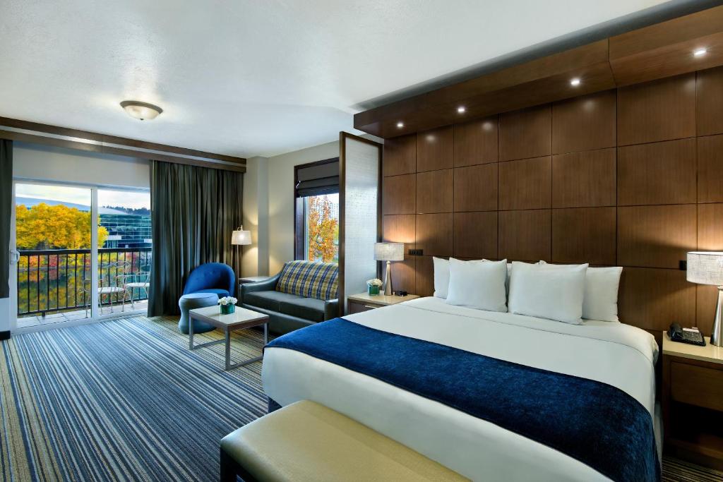 Oxford Suites Spokane Downtown في سبوكان: غرفه فندقيه بسرير وشرفه