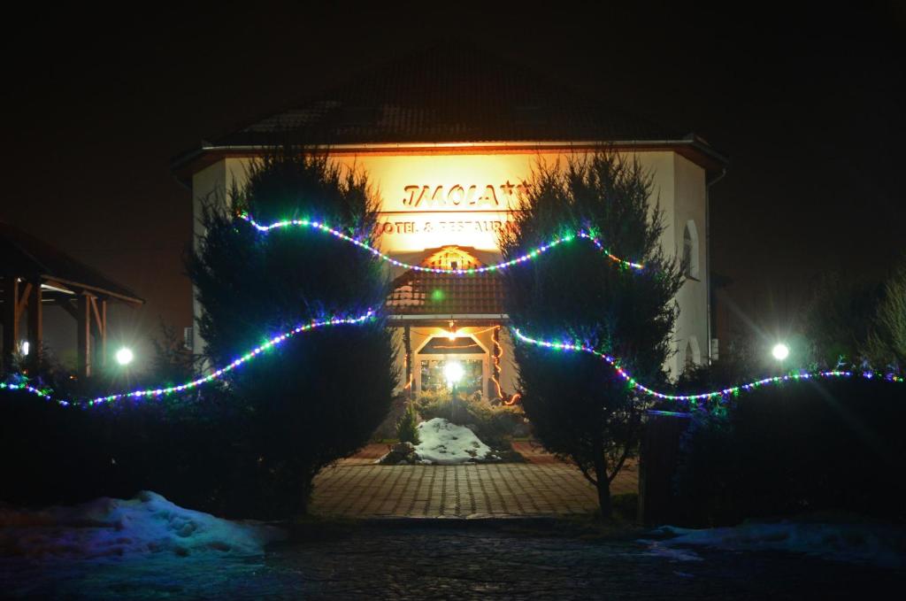 Um edifício com luzes de Natal à frente. em Imola Motel em Gheorgheni
