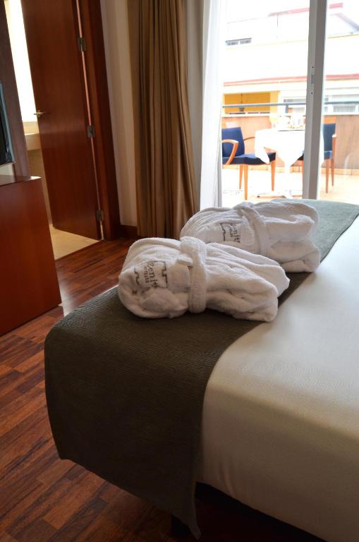 a hotel room with two towels on a bed at Zenit Málaga in Málaga