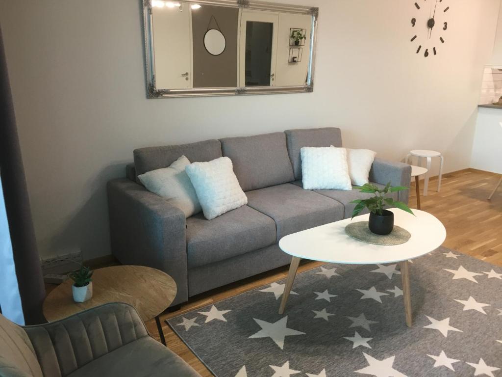 a living room with a couch and a table at StarHomes Double lux 7 in Oulu