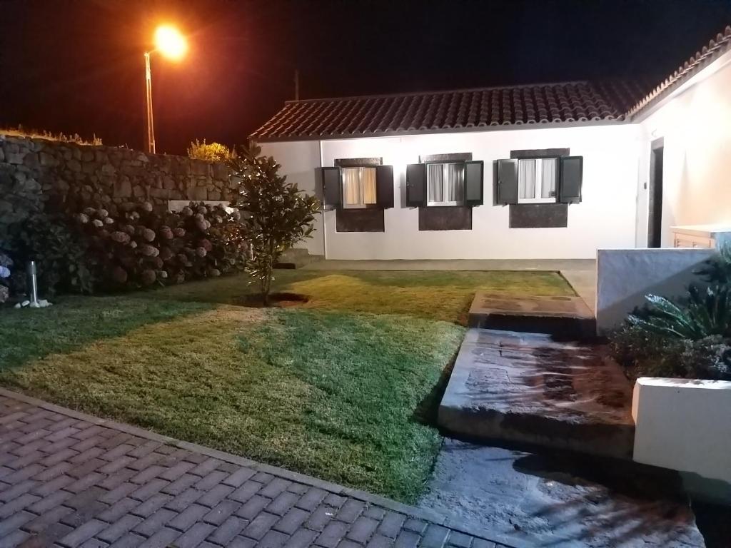 une maison la nuit avec un ruisseau dans la cour dans l'établissement Casa do Galante, à Nordeste