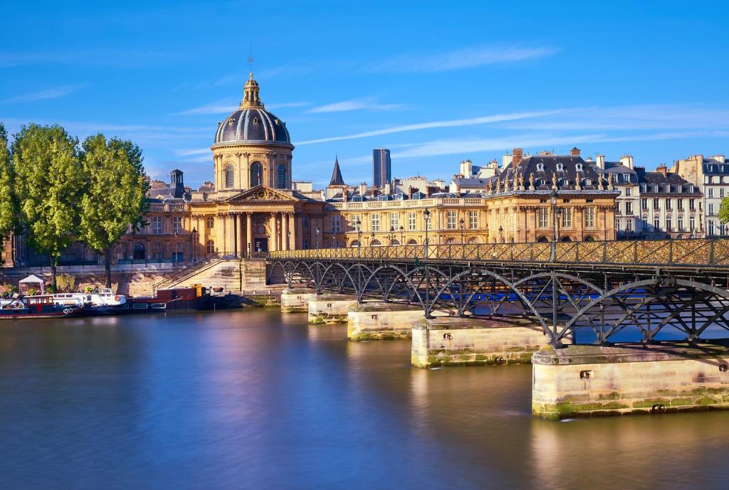 a bridge over a river in a city with buildings at TinyHouse Inn Saint-Germain-des-Près in Paris