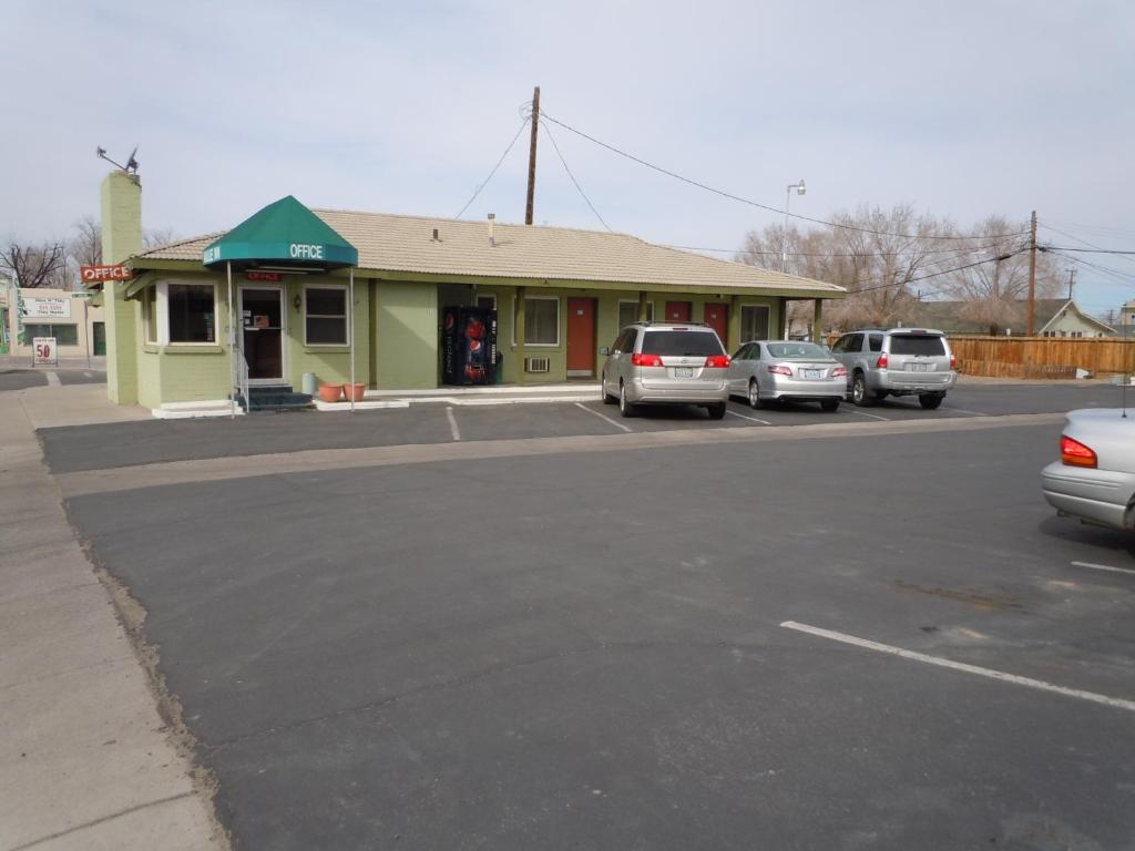 un estacionamiento con autos estacionados frente a una tienda en Value Inn, en Fallon