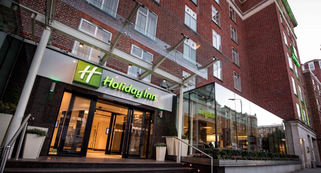 a store front of a brick building with a sign on it at Holiday Inn London Kensington High St., an IHG Hotel in London