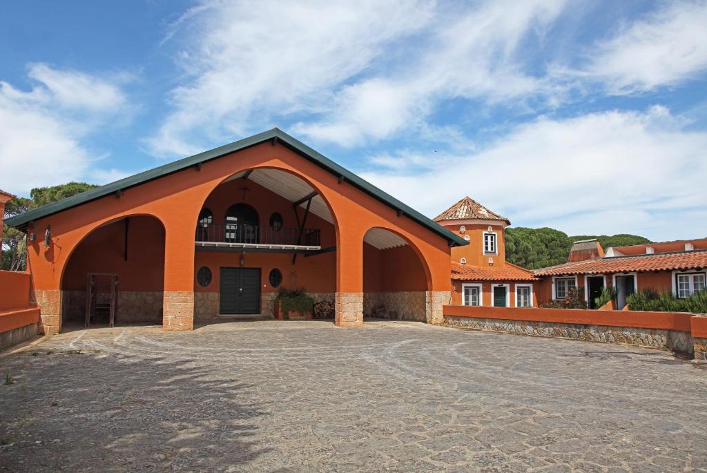 an orange building with an archway in a parking lot at Quinta da Bicuda in Cascais