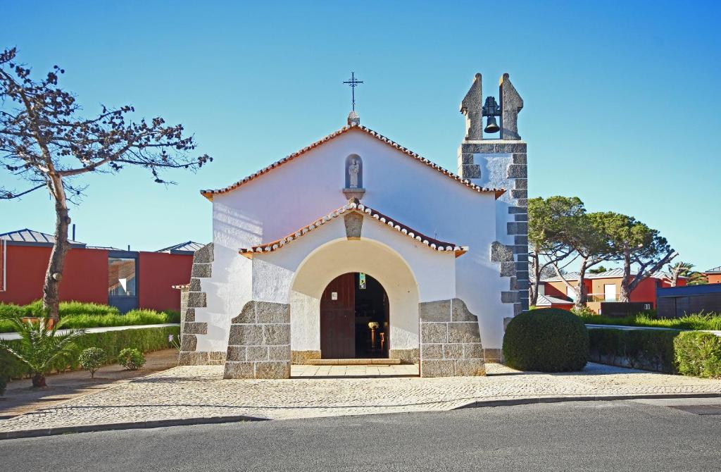 a small white church with a cross on the front at Quinta da Bicuda in Cascais