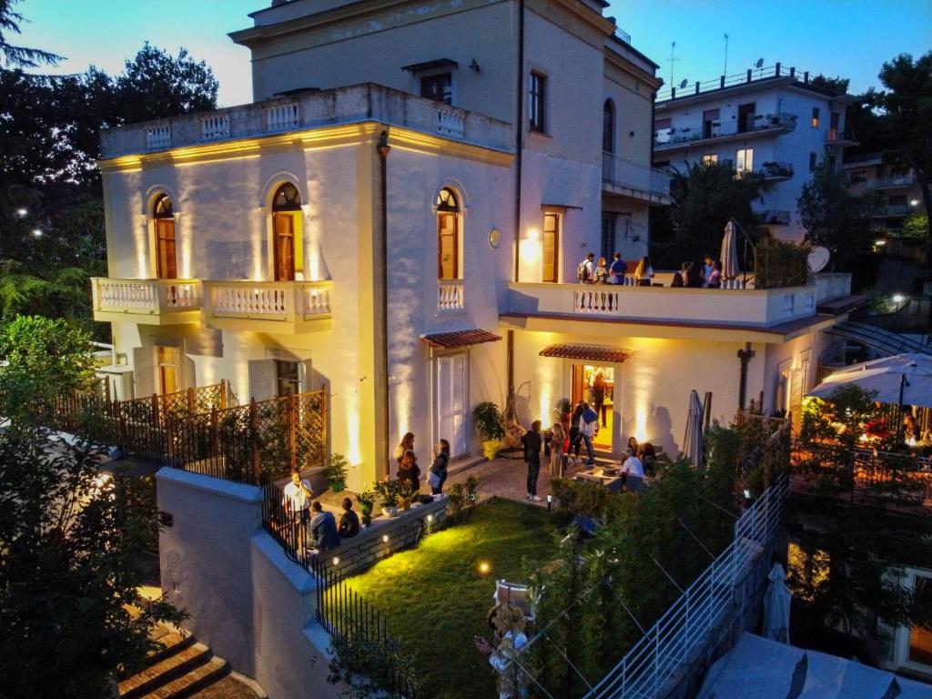 a group of people sitting on the balcony of a house at Relais Villa Montedonzelli in Naples