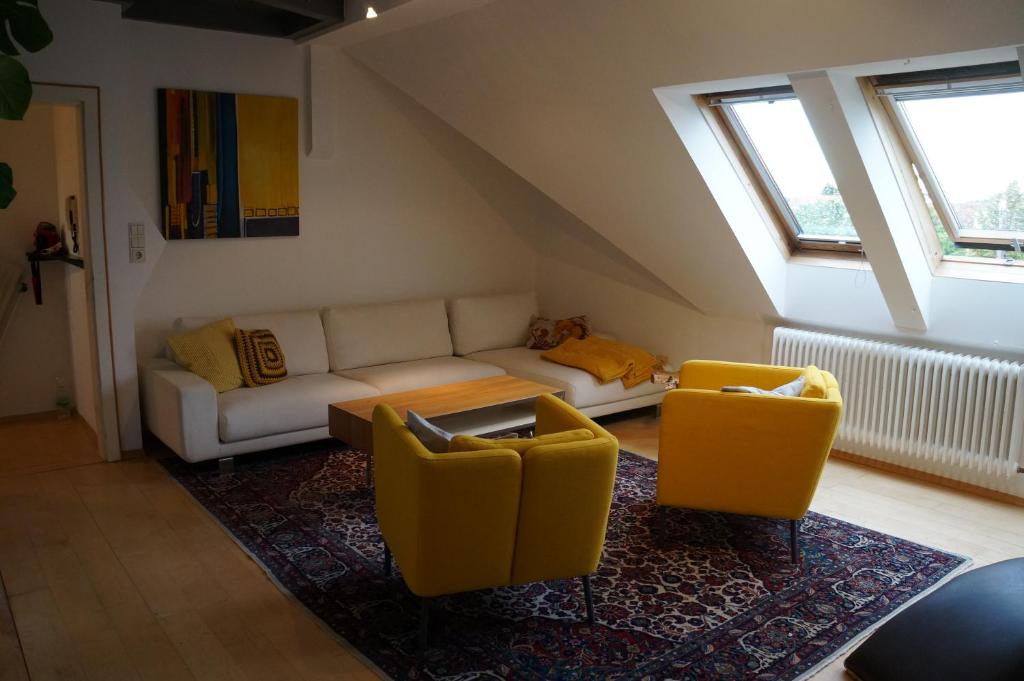 a living room with a couch and two yellow chairs at Ferienwohnung Donauauen in Orth an der Donau