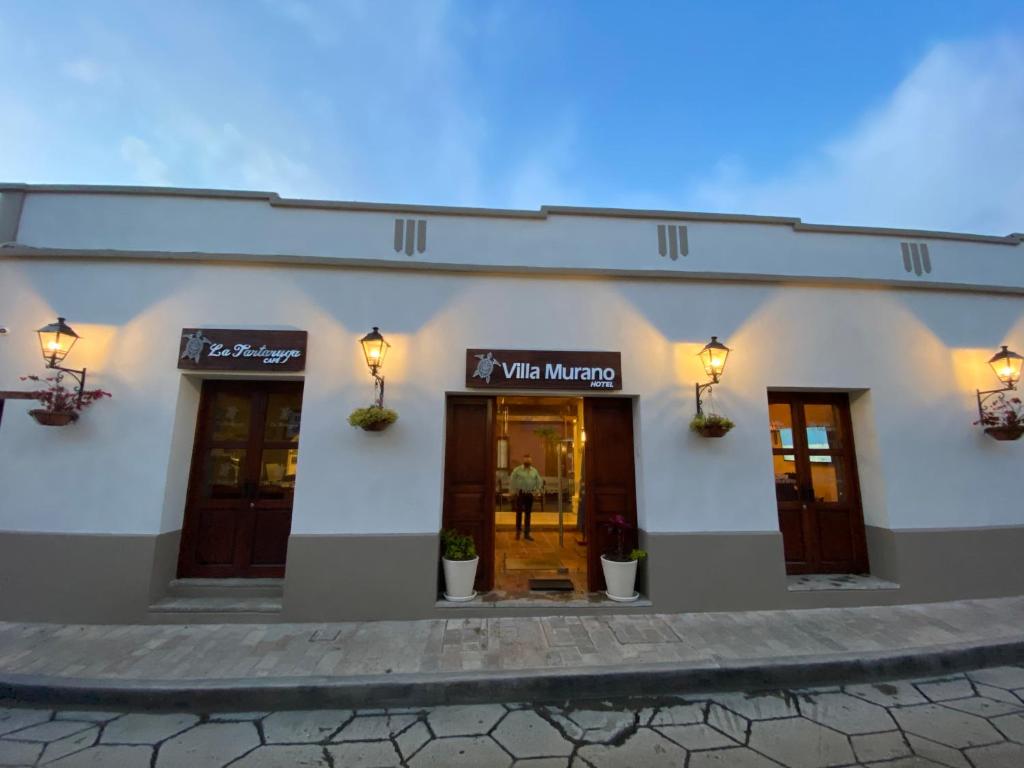 Un bâtiment blanc avec un panneau qui nous dit cartographes dans l'établissement Hotel Villa Murano, à San Cristóbal de Las Casas