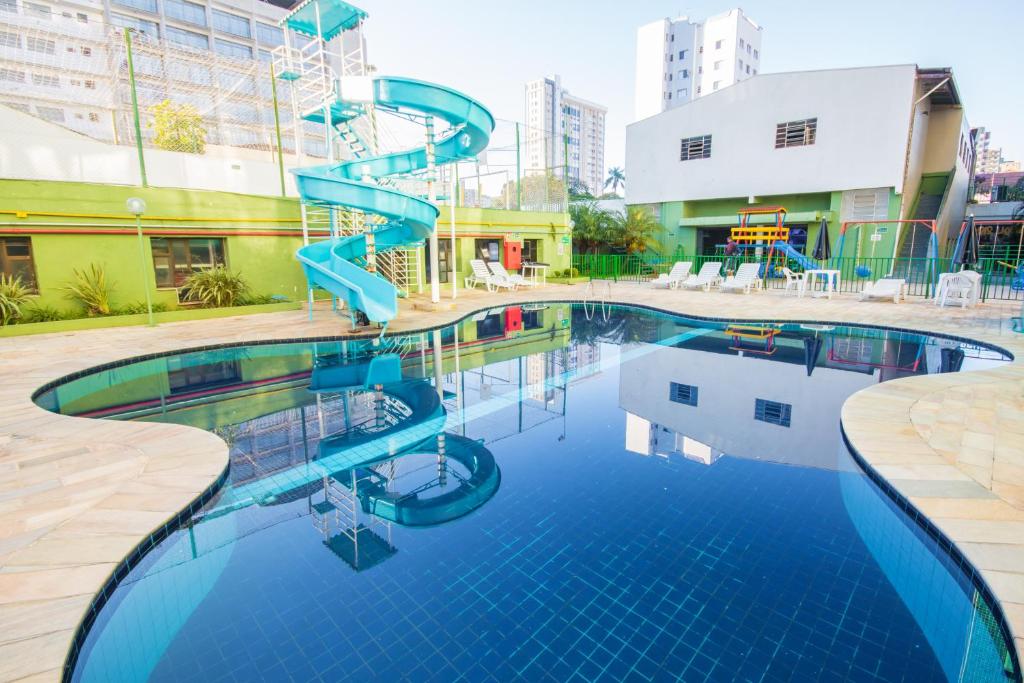 una piscina con un tobogán azul en un edificio en Hotel Nacional Inn Poços de Caldas - Lazer completo e Gastronomia no Centro, en Poços de Caldas