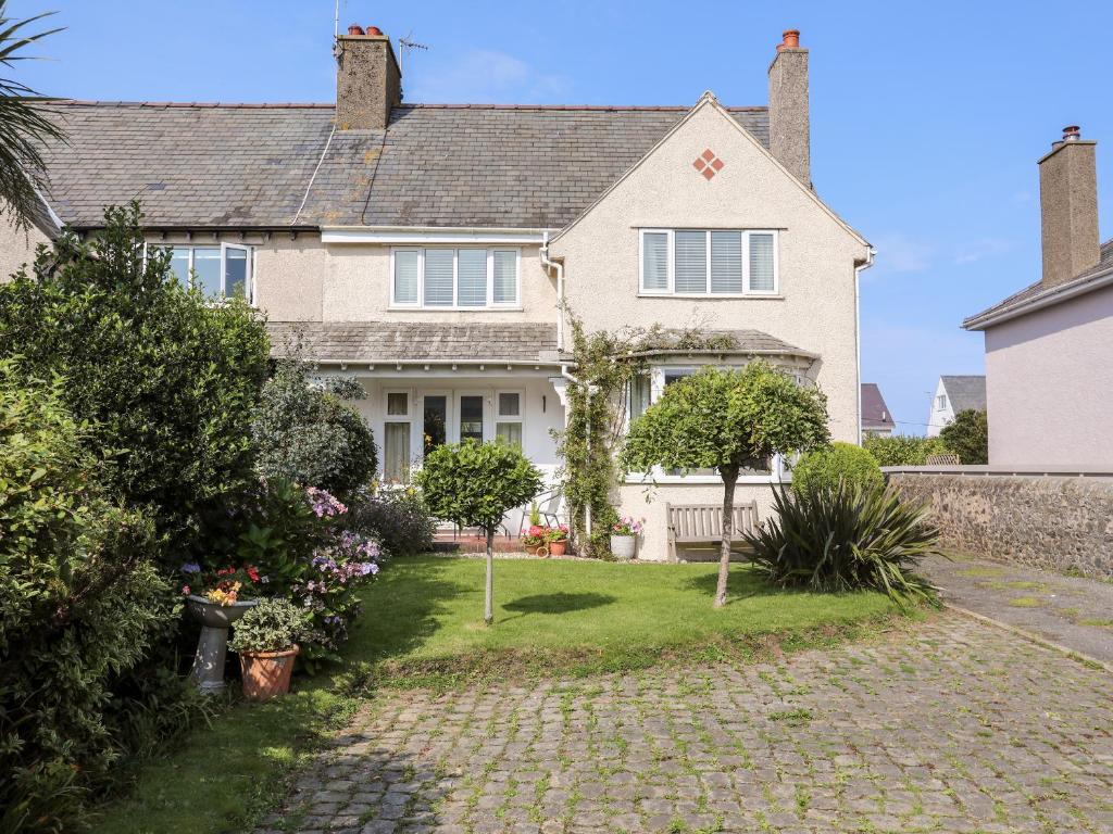 a large white house with a brick driveway at Afallon in Pwllheli