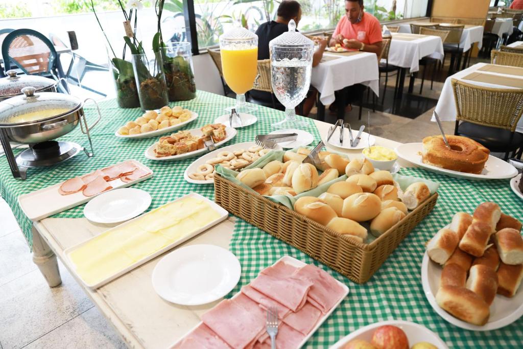a table topped with baskets of bread and pastries at Hotel BH Palace in Belo Horizonte