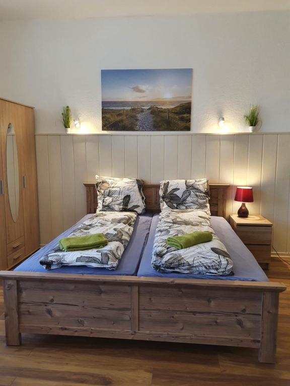 a large wooden bed with two pillows on it at Ferienwohnung in Glindow