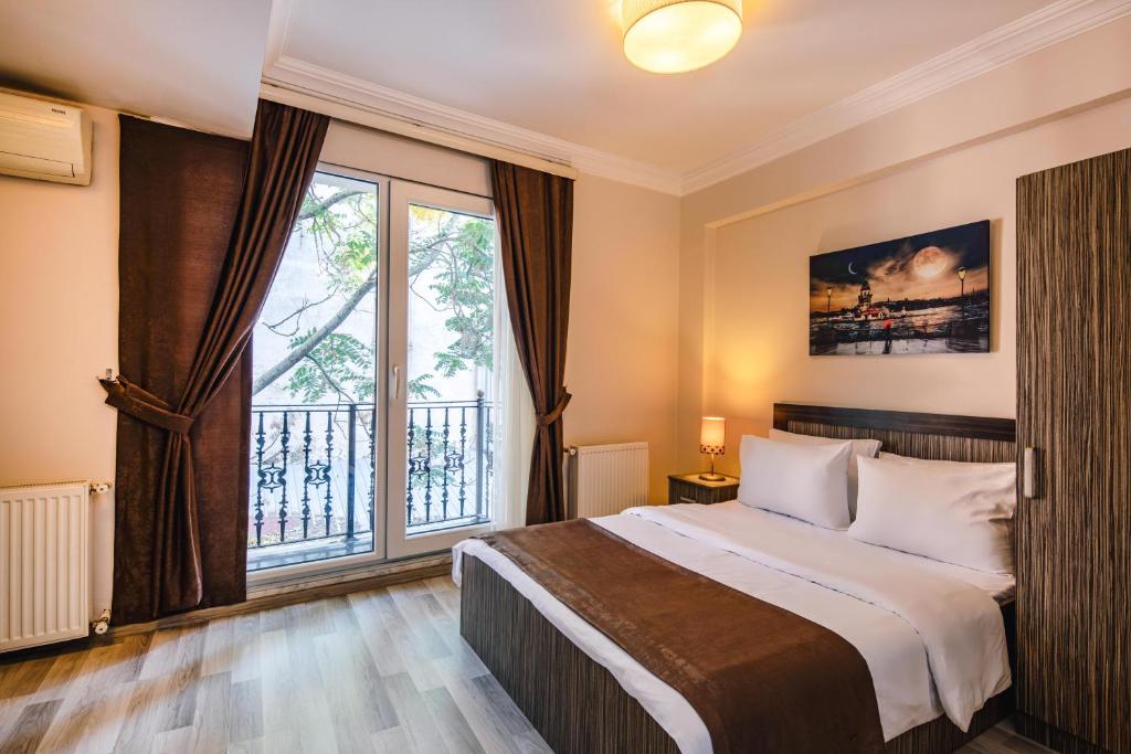 a bedroom with a bed and a large window at Hotel Taksimdays in Istanbul