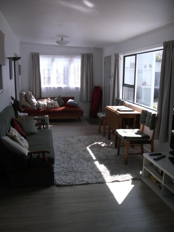 ein Wohnzimmer mit einem Sofa und einem Tisch in der Unterkunft Relax@99 in Featherston