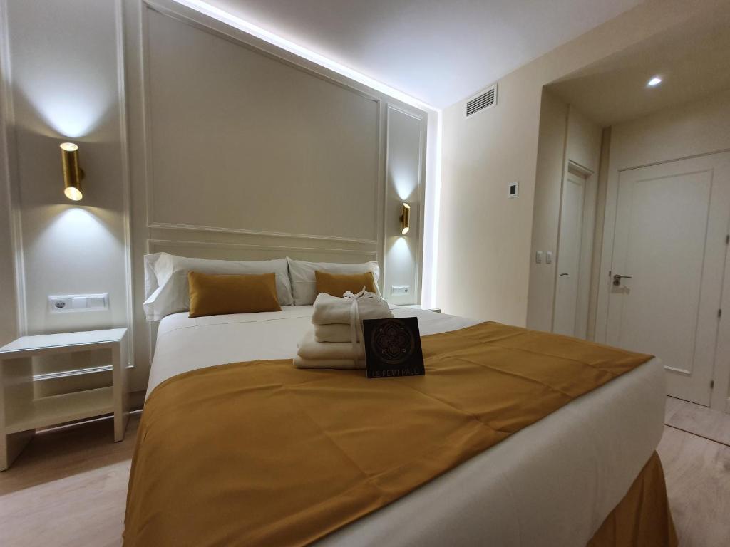 1 dormitorio con 1 cama grande y toallas. en Le Petit Palü-Ópera en Madrid