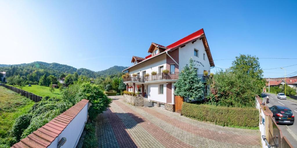 ein Haus mit einem roten Dach und einer Straße in der Unterkunft Casa Din Noua in Braşov