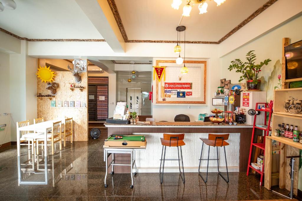 a kitchen with a counter and stools in a room at 墾丁秋莊會館 附限量停車位 不保證有位置 無法事先預留 背包房無車位 預訂後記得加Line聯繫 in Hengchun