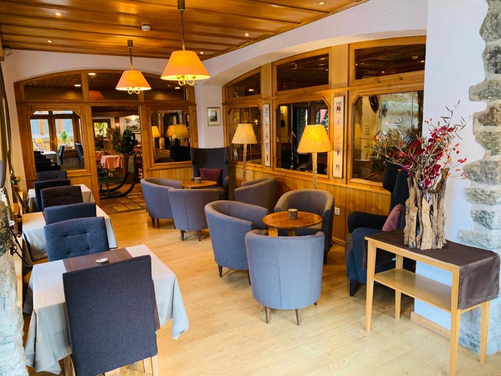 a restaurant with blue chairs and tables in a room at Alpenblick in Zermatt