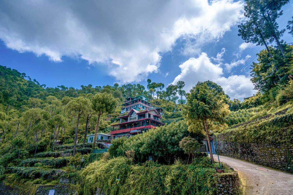 a house on the side of a hill with a road at StayVista at Cecil Cottages in Kasauli