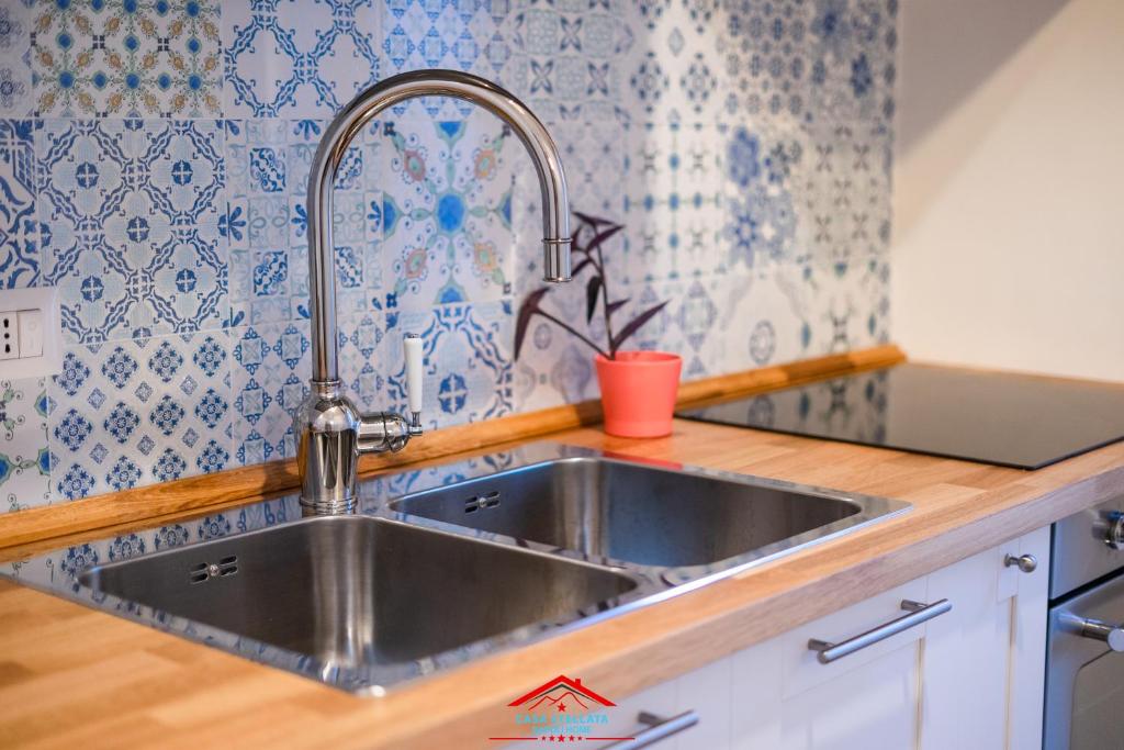 un lavandino in acciaio inossidabile in una cucina con piastrelle bianche e blu di Casa stellata Napoli home in the center a Napoli