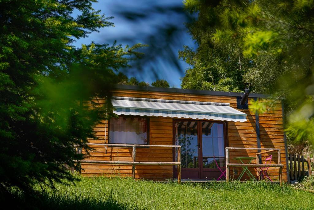 a log cabin with a porch and a awning at chalet 2 personnes in Mialanes