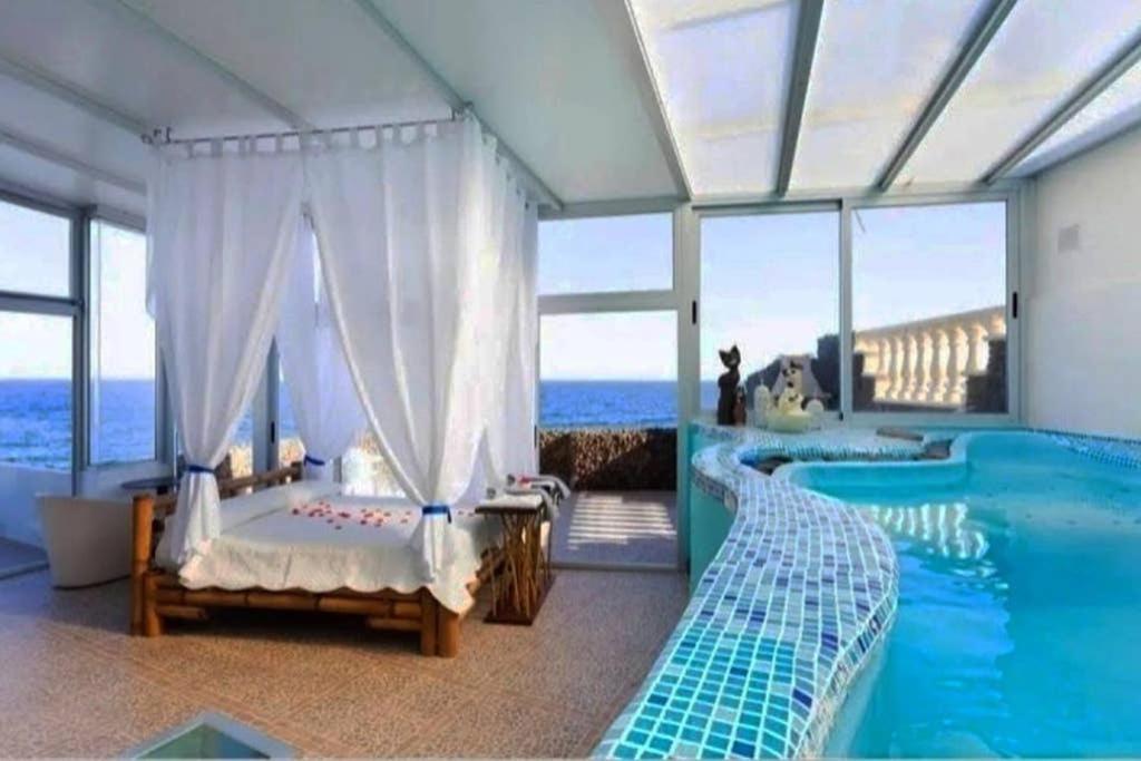 a bedroom with a bed and a swimming pool at Romantic Tenerife in Güimar