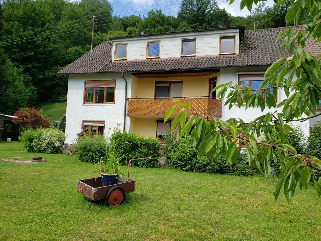 una casa con una carretilla delante de un patio en Ferienwohnung, Monteurwohnung Steger, en Frammersbach