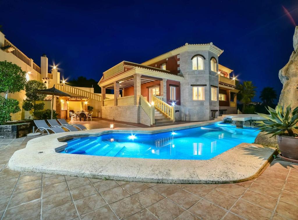 a large house with a swimming pool in front of it at Villa Alhambra - Plusholidays in Calpe