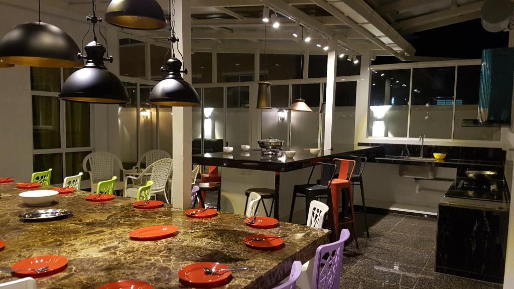 una cocina con una mesa con placas rojas. en Rose Hill Gardens, en Brinchang